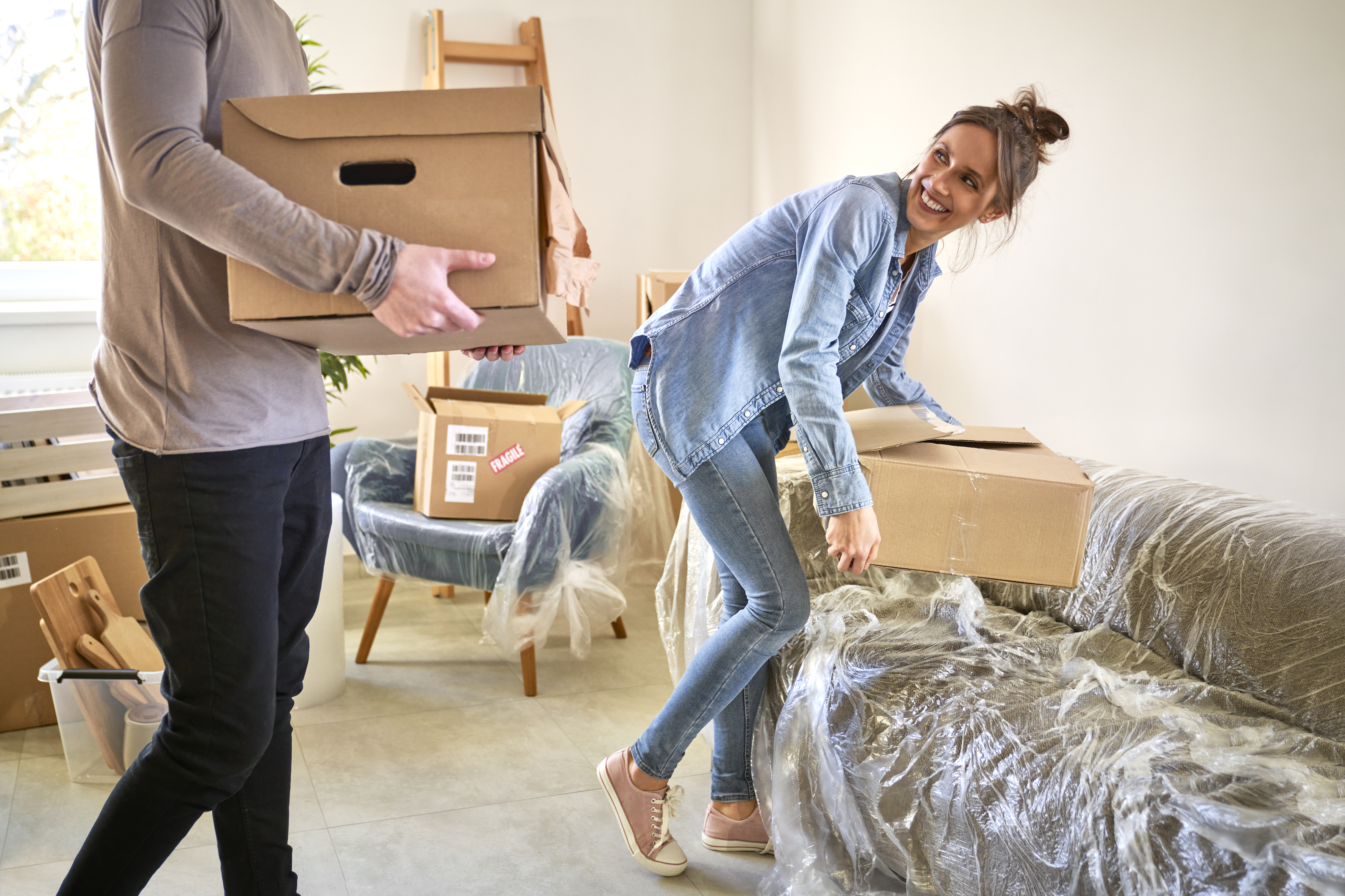 Caucasian couple carrying paper boxes while moving house